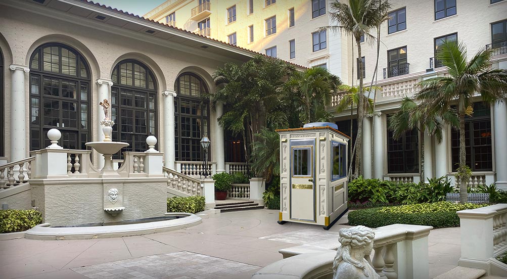 Security Guard Booth | The Guard Post 16 with a 'Dover White' color, in the plaza of a luxury resort with columned esplanade.