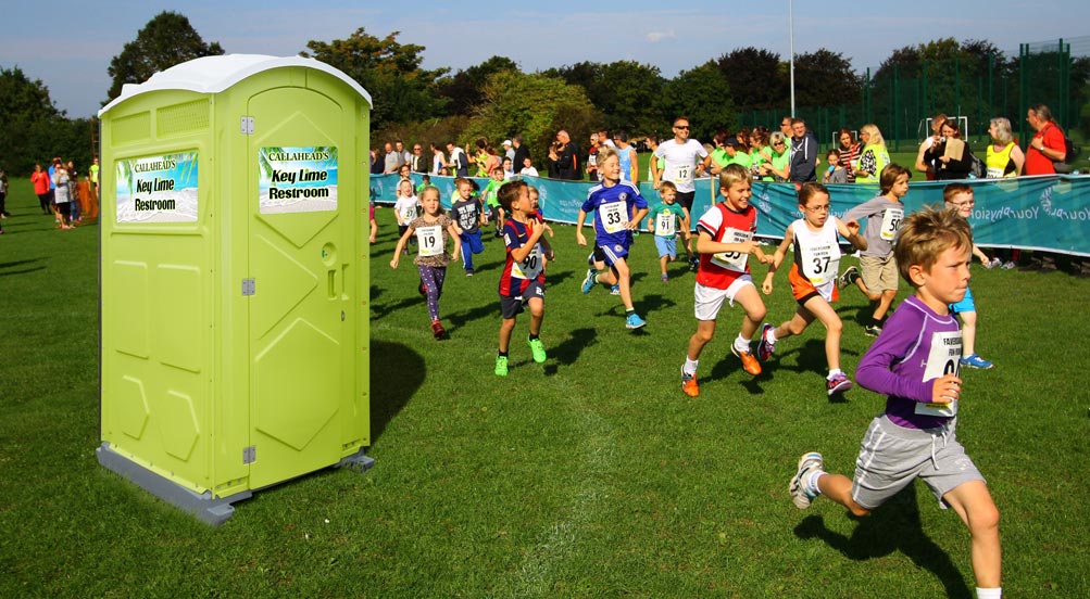 Key Lime Portable Toilet  | The Key Lime Portable Toilet at a children's race in a park.