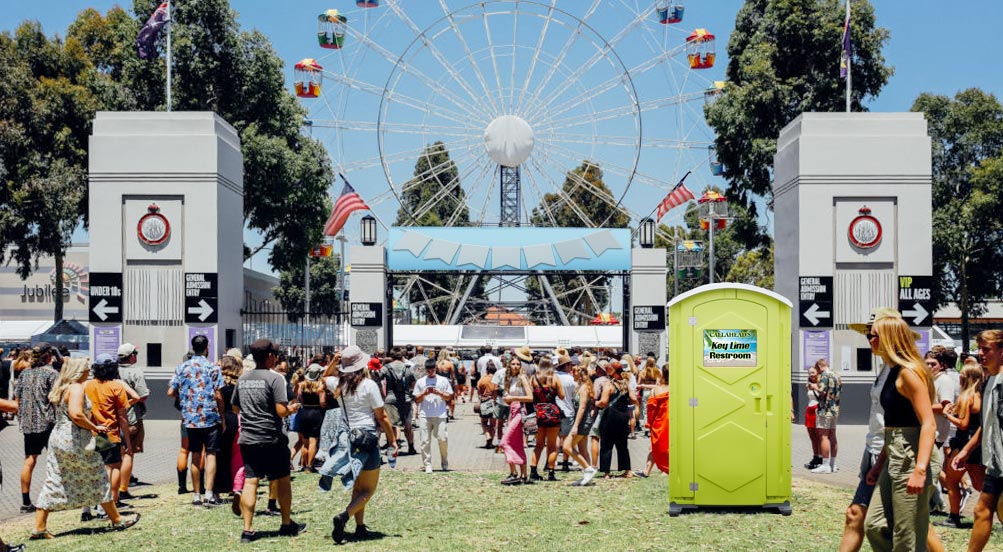 Key Lime Portable Restroom | Key Lime Portable Toilet shown at a fairgrounds with a ferris wheel in the background.