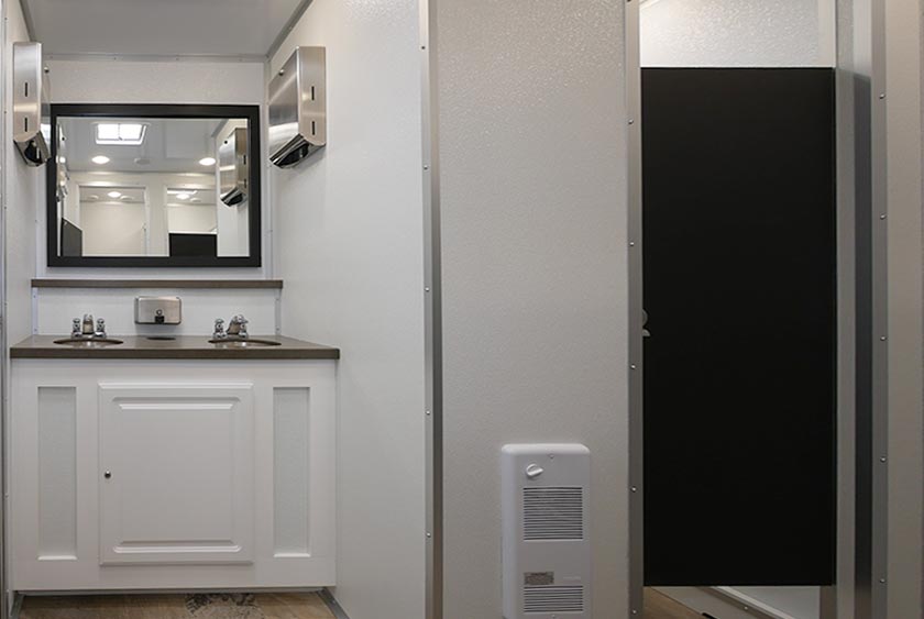 WOMEN'S SIDE VANITY AREA IS ADJACENT TO ONE OF THE FOUR PRIVATE TOILET STALLS