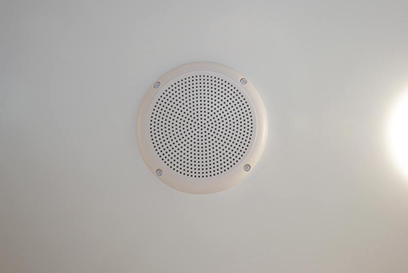 A CENTRAL MUSIC SYSTEM HAS AM/FM RADIO AND CD PLAYER WITH CEILING MOUNTED SPEAKERS 