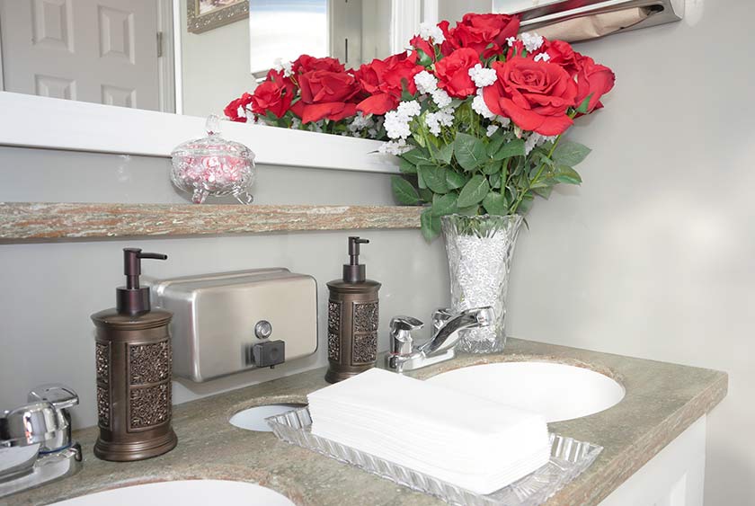 BEAUTIFULLY APPOINTED WITH FOLRAL ARRANGEMENTS, DESIGNER DISPENSERS AND FILLED CANDY DISHES