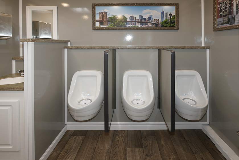 THREE SLOAN PORCELAIN URINALS WITH PRIVACY DIVIDERS ON MEN'S SIDE 