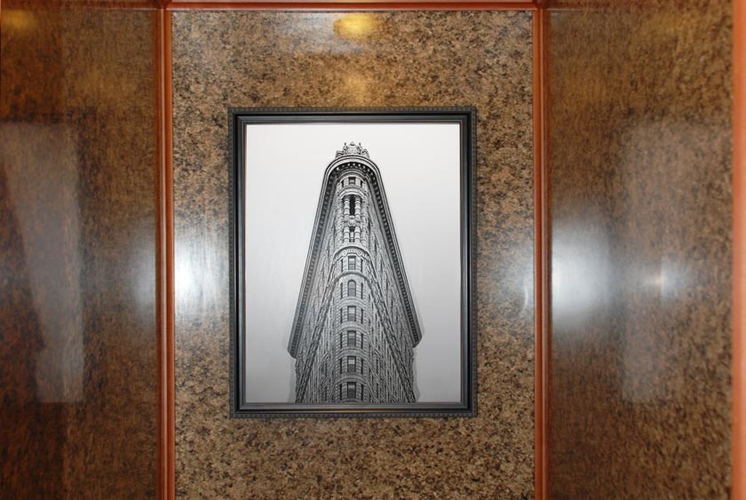 DETAIL OF CLASSIC FRAMED ARTWORK WITHIN BATHROOM STALL