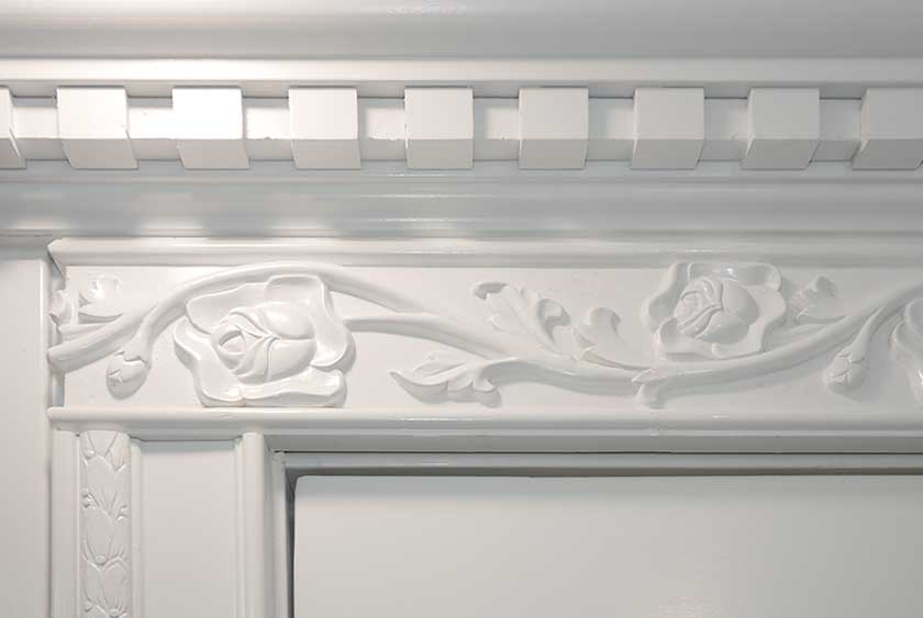 CUSTOM WOODWORK INCLUDES DENTAL CROWN MOLDING AND ORNATE FRIEZE OVER THE DOO