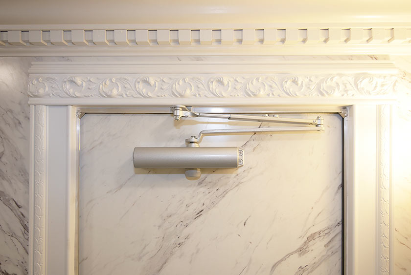 CROWN MOLDING WITH DENTAL WORK AND DOOR FRIEZE MOLDING SHOWN ABOVE THE SELF-CLOSING DOOR