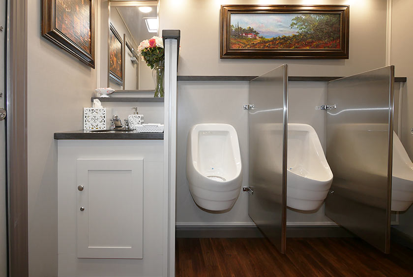 MEN'S RESTROOM HAS ONE VANITY SINK, TWO PRIVATE STALLS AND THREE URINALS